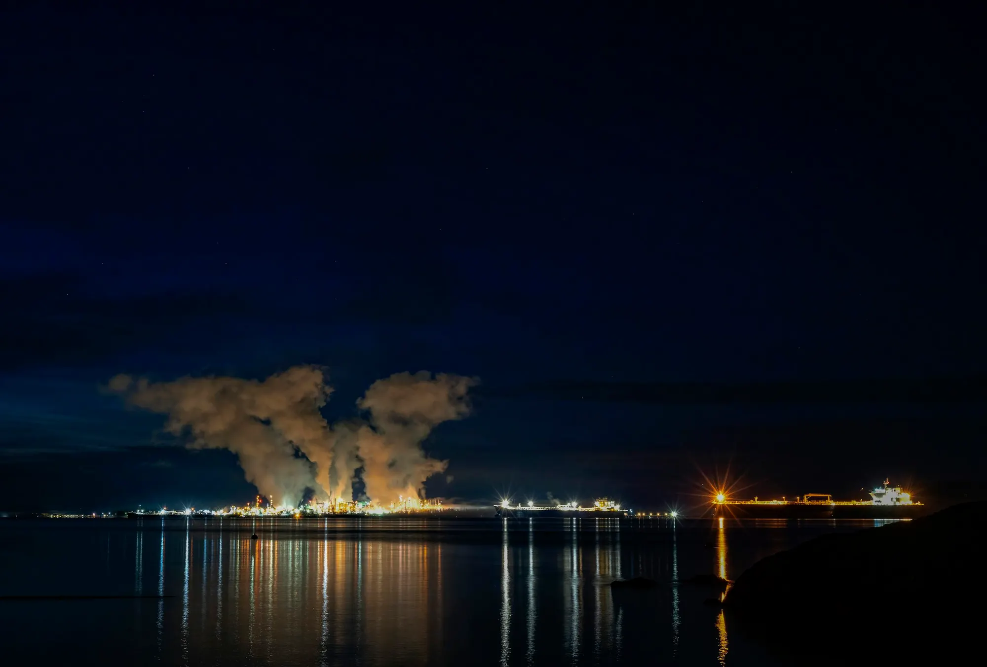 A refinery and tanker terminal on the waterfront at night